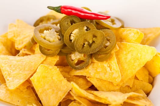 Bowl with nachos tortillas with pepperoni and fresh tomato salsa in a plate insulated against a white background