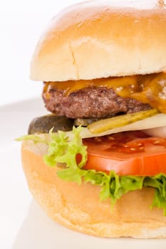 Delicious hamburger cheeseburger with bacon egg and salad on a plate isolated on a white background