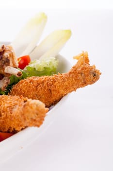 Huge barbecue plate with mixed meat and steaks on salad isolated against a white background