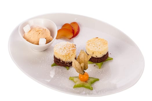 Brownie chocolate brownie with ice cream and plums prepared on a plate insulated against a white background