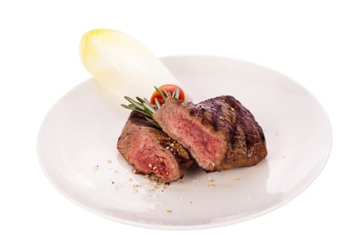 Medium fried beef steak fillet with pepper and rosemary sliced on a plate insulated against white background