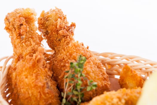 Crispy fried chicken wings with a dip on a plate insulated against a white background