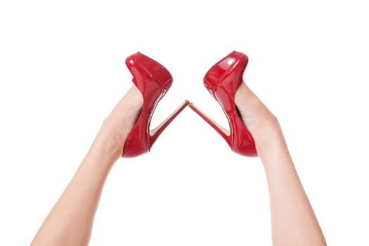 Sexy long legs of an attractive woman with red stilettos isolated against a white background