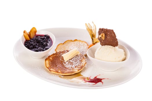 Delicious sweet pancakes as desser with vanilla ice cream prepared on a white plate insulated against a white background