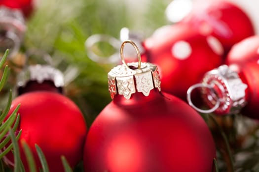Beautiful red Christmas balls with small white dots with green fir branches on a jute sack
