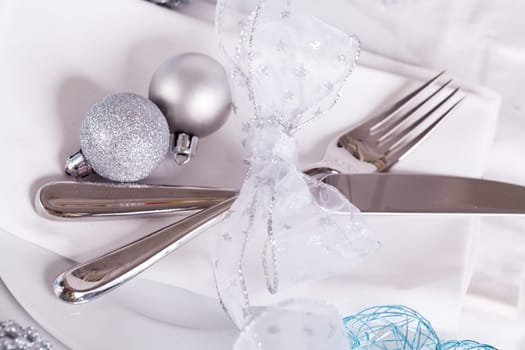 Stylish table with Christmas decoration in turquoise and silver shiny with cutlery