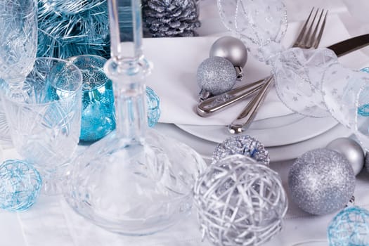 Stylish table with Christmas decoration in turquoise and silver shiny with cutlery