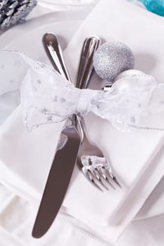 Stylish table with Christmas decoration in turquoise and silver shiny with cutlery