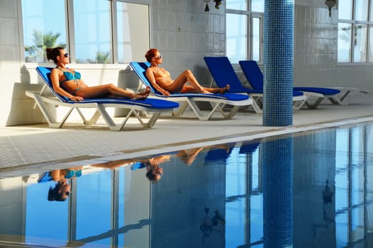 Two young women at the swimming pool.