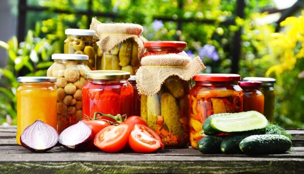 Jars of pickled vegetables in the garden. Marinated food.