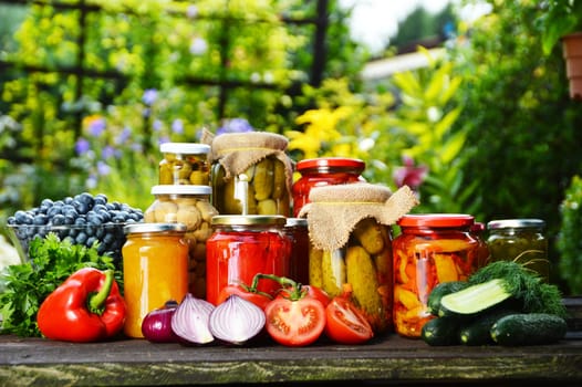 Jars of pickled vegetables in the garden. Marinated food.
