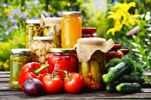 Jars of pickled vegetables in the garden. Marinated food.