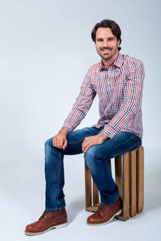 Young man with beard and dark hair with jeans and carated shirt