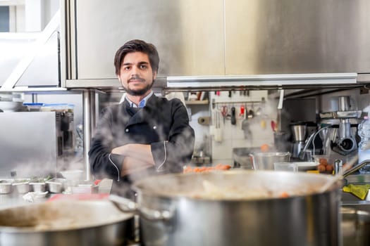 young adult chef in the restaurant kitchen while cooking at the herd preparation