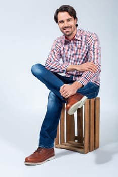 Young man with beard and dark hair with jeans and carated shirt