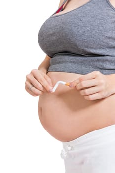 Pregnant woman breaks a cigarette in front of her baby belly isolated against white background