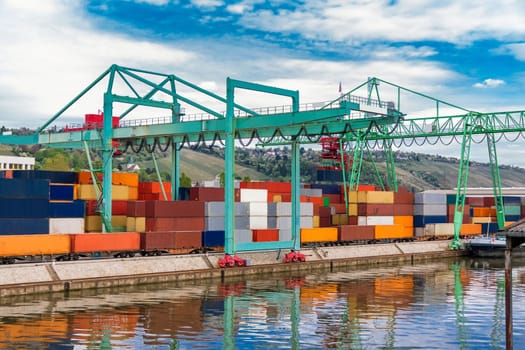 Dock in the port with stacked containers at the dock for import and export cargo with blue sky