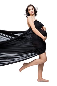 Young attractive pregnant woman wrapped in black fabric insulated against white background