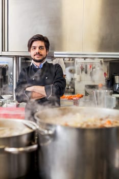 young adult chef in the restaurant kitchen while cooking at the herd preparation