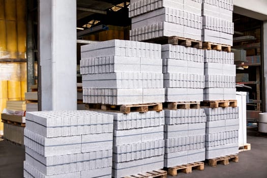 Red brick bricks on a pallet packed in a warehouse in the industrial area