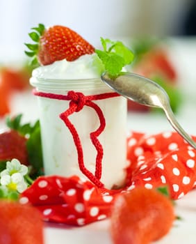 Fresh yoghurt with strawberries in a glass insulated on a white background