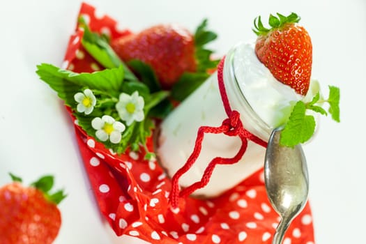 Fresh yoghurt with strawberries in a glass insulated on a white background