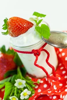 Fresh yoghurt with strawberries in a glass insulated on a white background