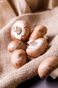 Fresh braund champignons in sunlight on a wooden table in daylight