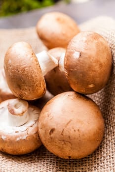 Fresh braund champignons in sunlight on a wooden table in daylight