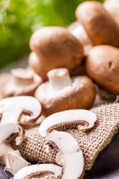 Fresh braund champignons in sunlight on a wooden table in daylight