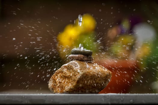 Beautiful splashing water on stones in a garden