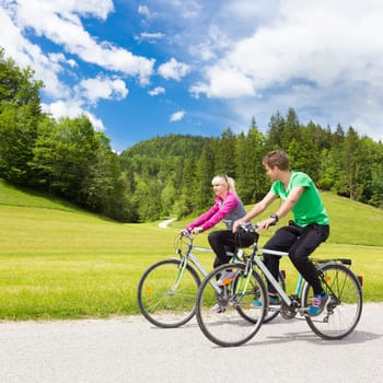 Young spoty active cople biking in nature. Active lifestyle. Activities and recreation outdoors.