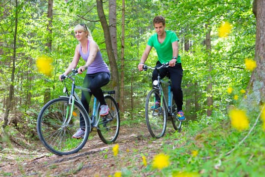 Young spoty active cople biking in nature. Active lifestyle. Activities and recreation outdoors.