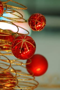 Some christmas balls decorated on a golden frame made tree