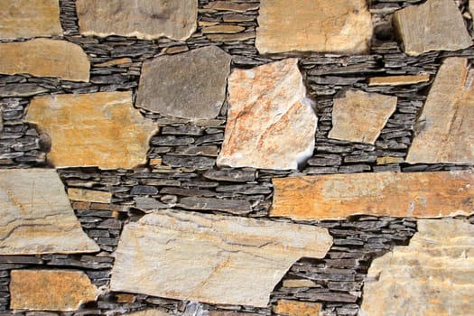 Beautiful mosaic of stones and slabs neatly stacked in wall