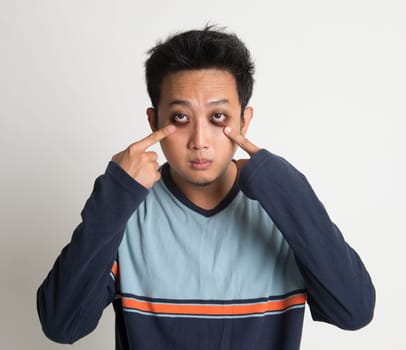 Asian man insomnia, with big eyes bag, on plain background