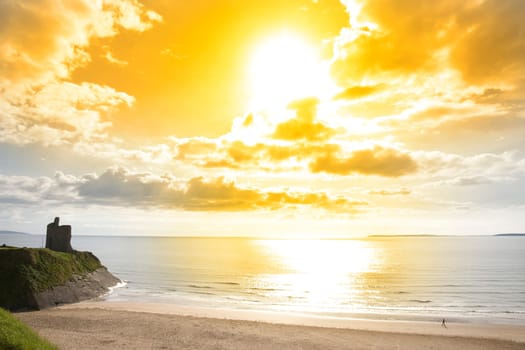 Beautiful yellow sun over the Ballybunion beach and castle in Ireland on a summers day