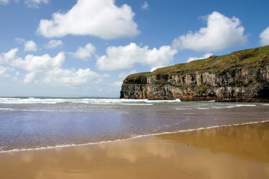 Ballybunion beach and cliffs on the Atlantic coast in Ireland with waves crashing on the cliffs