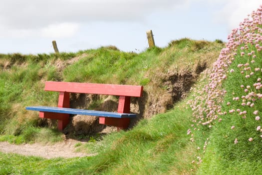 red and blue bench positioned at the edge on top of a cliff