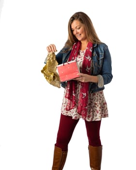 Forty year old woman, wearing  stylish bohemian clothing, opening a gift bag