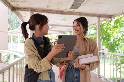 Two college student female friends smile ready for class at the university campus.