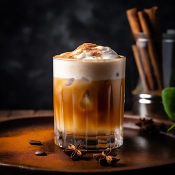 Glass of tasty Brown Butter autumn latte macchiato coffee with cinnamon on dark background. Fall and winter warm drinks concept