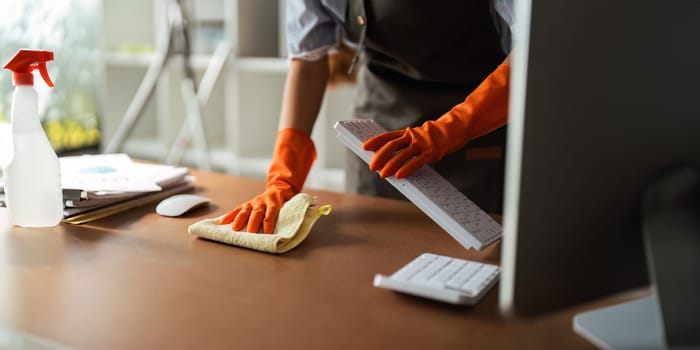 Asian woman cleaning in work room at home. Young woman housekeeper cleaner use a cloth to wipe equipment for working. concept housekeeping housework cleaning.