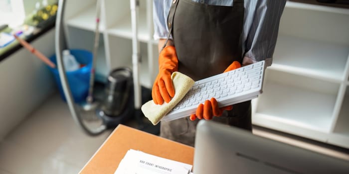 Asian woman cleaning in work room at home. Young woman housekeeper cleaner use a cloth to wipe equipment for working. concept housekeeping housework cleaning.