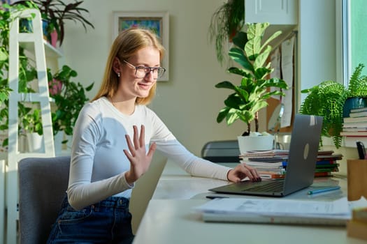 Teenage girl high school student having video conference on laptop computer at home, remote lesson learning language online lecture educational webinar. E-education knowledge adolescence technology