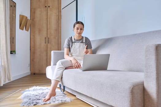 Teen girl at home lying on couch using laptop. Technology for learning leisure communication, modern lifestyle, adolescence concept