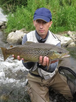Fisherman catched big brown trout