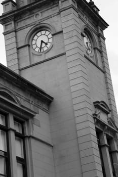 Clock tower of an old building, in black and white