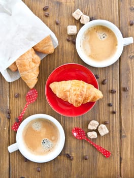 Cups with coffee and fresh croissants