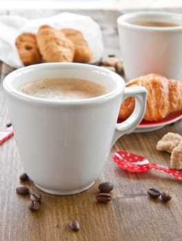 Cup with coffee and fresh croissants